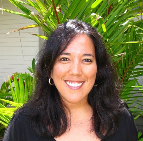 A photo of Kim, a woman with long dark hair, wearing hoop earrings.